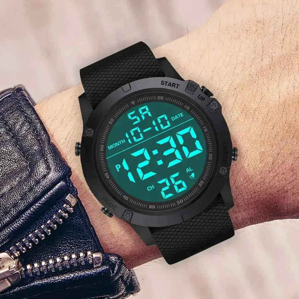 Digital adventure watch worn on a wrist, featuring a rugged black case, textured silicone strap, and bright teal backlit digital display showing time, date, and alarm indicators.