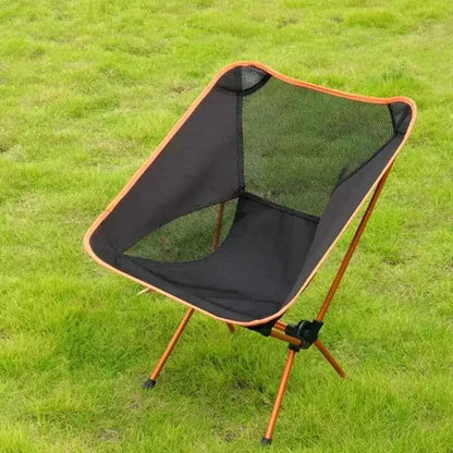 Lightweight folding camping moon chair with breathable mesh seat and aluminum frame set up outdoors on grass, compact portable chair for camping and hiking